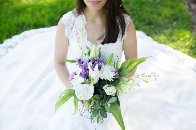 Bella giovane sposa in una corona con un bouquet in mano