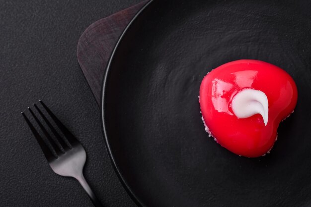 Bella gustosa torta cheesecake di colore rosso a forma di cuore