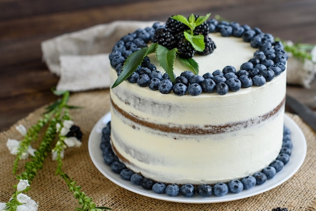 Bella gustosa torta con crema bianca e bacche di mirtillo