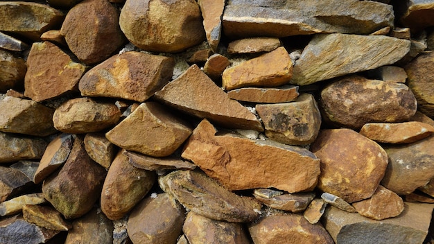 Bella immagine del modello di sfondo di un muro fatto di pietre rotonde di colore rosso con rocce Texture