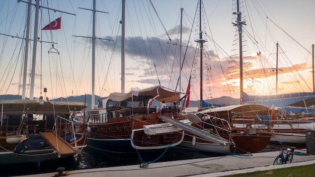 Bella immagine di molti yacht e barche di legno ormeggiate in porto al tramonto