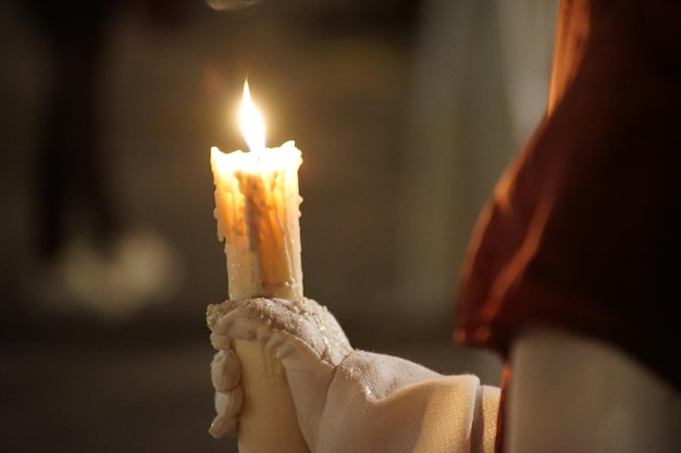 Bella immagine di un nazareno e la sua candela in processione