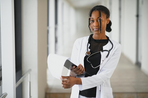 Bella infermiera pediatrica femminile afroamericana in ufficio moderno