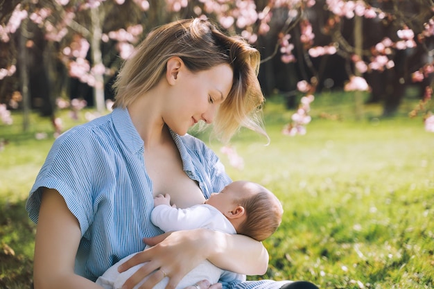 Bella madre che allatta al seno bambino Giovane donna che allatta al seno il suo neonato Concetto di allattamento infantile periodo postpartum maternità naturale Madre e bambino sulla natura all'aperto