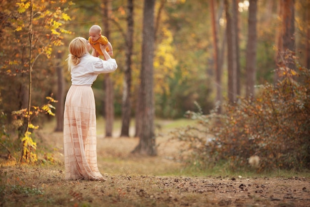 bella madre che tiene in braccio la sua piccola mamma ama suo figlio tempo in famiglia in autunno natura copia spazio