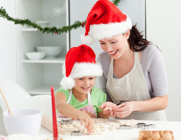 Bella madre e figlia che preparano i biscotti di Natale