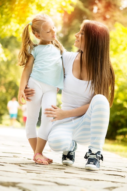 Bella madre e figlia che si divertono nel parco il giorno di primavera.