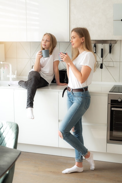 bella mamma con la figlia in cucina con le tazze