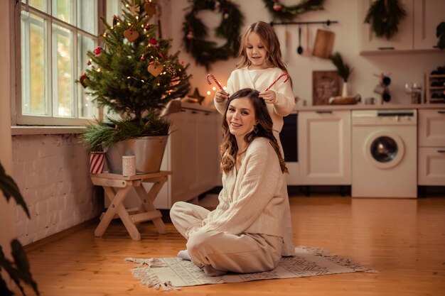 Bella mamma e figlia vicino all'albero di Natale