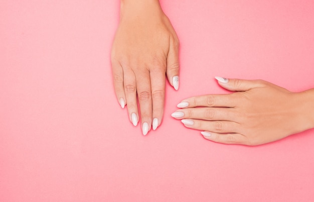 Bella manicure femminile alla moda sul rosa