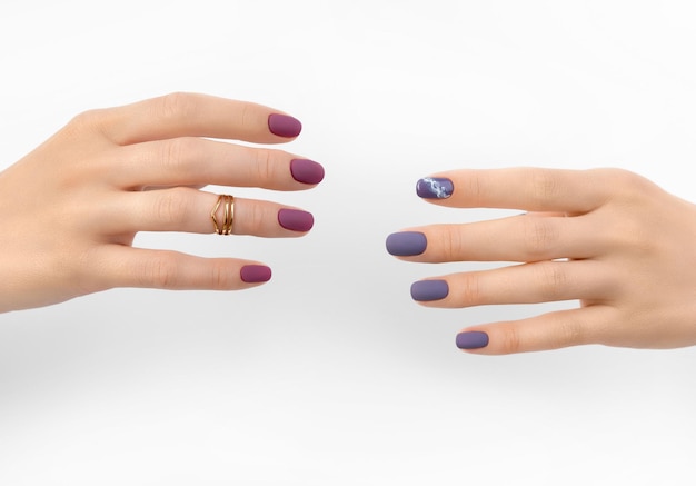 Bella manicure opaca bordeaux viola su sfondo bianco