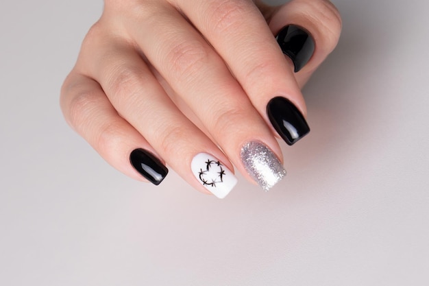 Bella mano femminile con manicure nera unghie disegno cuori su sfondo bianco