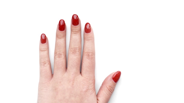 Bella mano femminile con manicure rossa fresca e unghie isolate su sfondo bianco