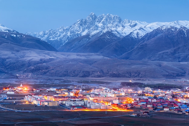 Bella montagna della neve del paesaggio e villaggio tibetano alla provincia del Sichuan, Cina