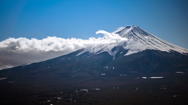 Bella montagna Fuji con manto nevoso in cima con nuvole, luogo di viaggio di riferimento. Paesaggio giapponese di stagioni invernali. Il Monte Fuji è la montagna più alta del Giappone e popolare tra i turisti stranieri.