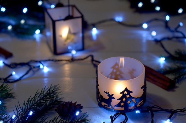 Bella natura morta invernale Candele di arredamento di Capodanno in candelieri e una ghirlanda