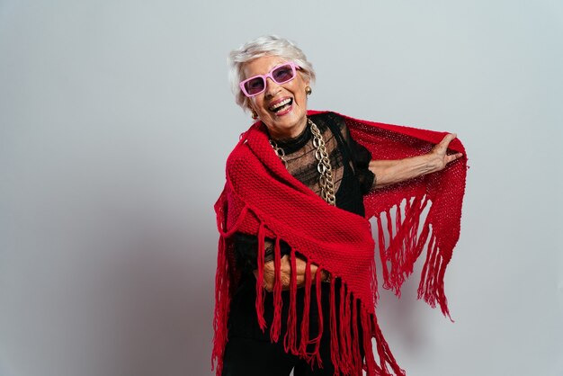 Bella nonna in posa in studio indossando abiti alla moda e facendo festa