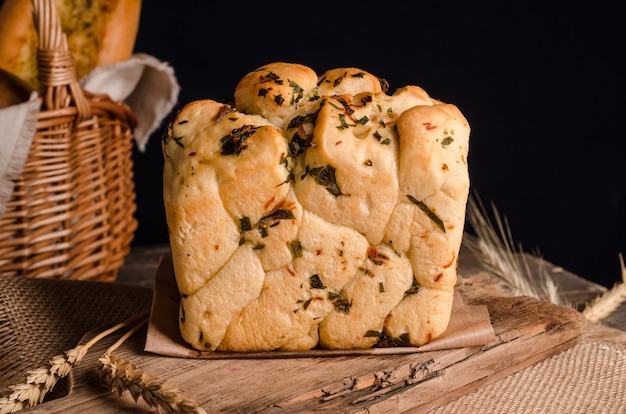 Bella pagnotta di pane bianco con parte superiore riccia su fondo in legno