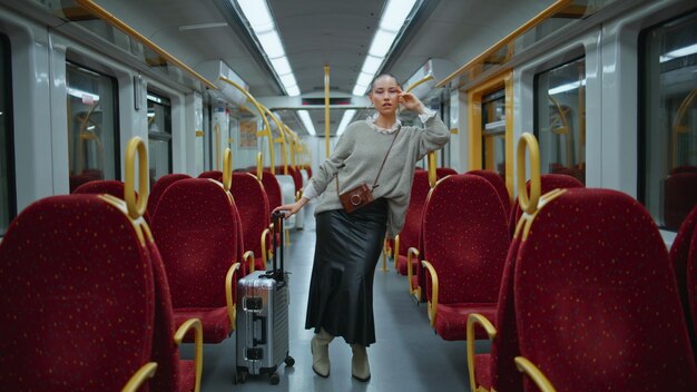 Bella passeggera che posa il treno appoggiata al corrimano zoom in modello di capelli corti