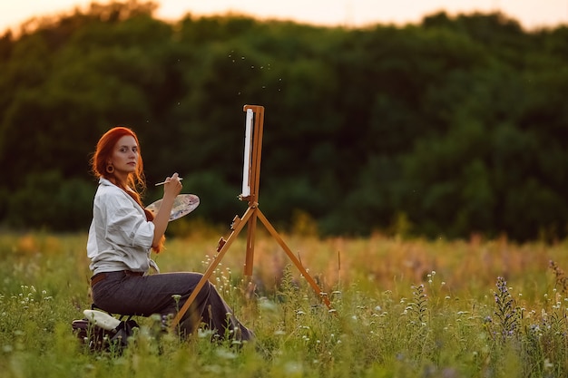 Bella pittura femminile dell'artista al tramonto in natura