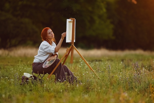 Bella pittura femminile dell'artista al tramonto in natura