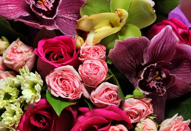 Bella primavera bouquet di fiori di close-up su uno sfondo rosa. Bouquet di rose, crisantemi, gigli.