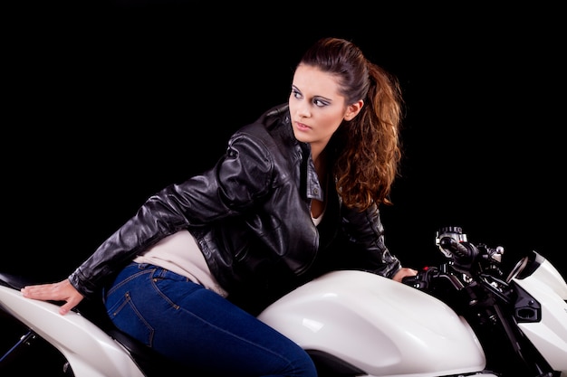 Bella ragazza accanto a una moto bianca