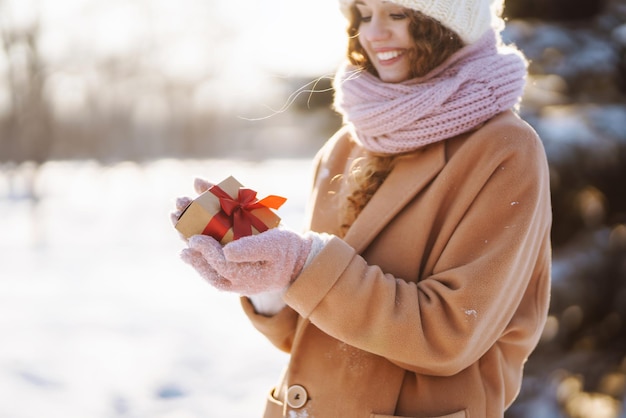 Bella ragazza adolescente con un regalo nelle sue mani inverno adolescenziale all'aperto