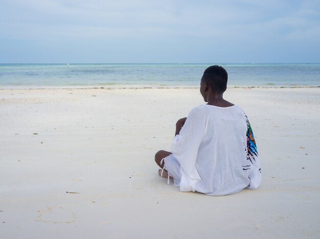 Bella ragazza africana sulla spiaggia tropicale