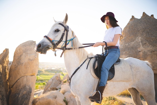 Bella ragazza all'aperto in montagna con il suo fedele cavallo