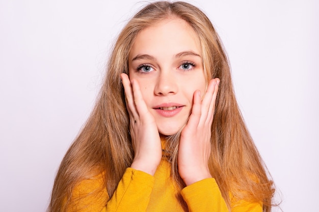 Bella ragazza alla moda hipster. Foto di giovane donna piacevole positiva in gambaletto giallo con sfondo bianco. sorpreso