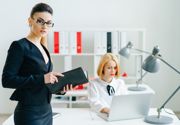 Bella ragazza allegra sorridente nello sguardo sul posto di lavoro