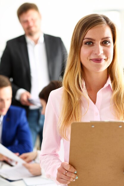 Bella ragazza allegra sorridente sul posto di lavoro