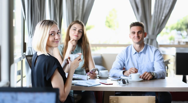 Bella ragazza allegra sorridente sul posto di lavoro