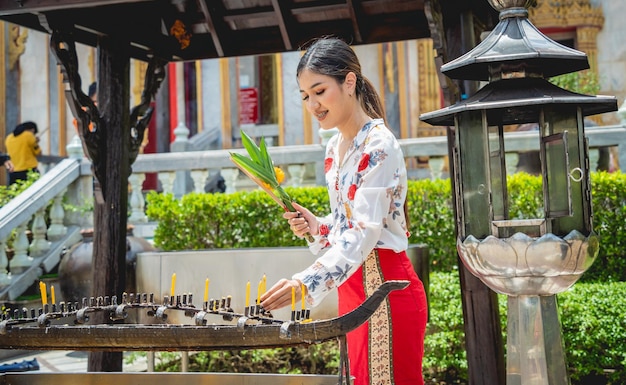 Bella ragazza asiatica al grande tempio buddista vestita in costume tradizionale