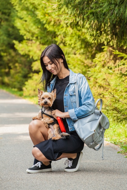 Bella ragazza asiatica per una passeggiata nel parco in estate con il suo cane Yorkshire Terrier