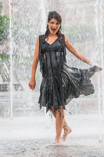 Bella ragazza balla in una fontana