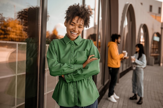 Bella ragazza. Bella ragazza dai capelli ricci in camicia verde che sorride bene