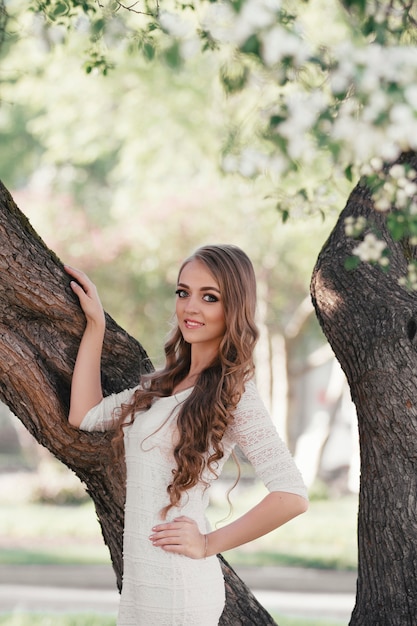 bella ragazza bionda che cammina in un parco di primavera