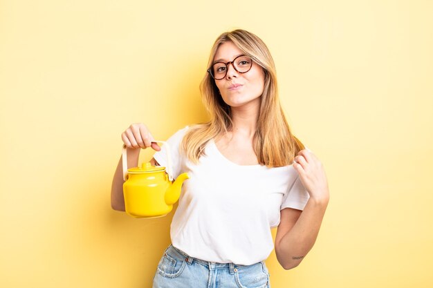 Bella ragazza bionda che sembra arrogante concetto positivo e orgoglioso di teiera