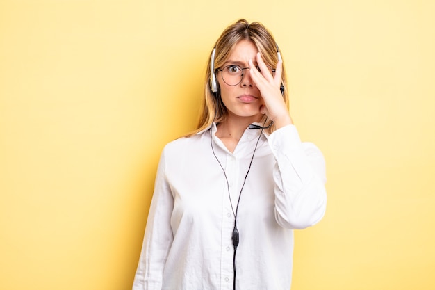 Bella ragazza bionda che si sente annoiata, frustrata e assonnata dopo una noiosa. concetto di auricolare