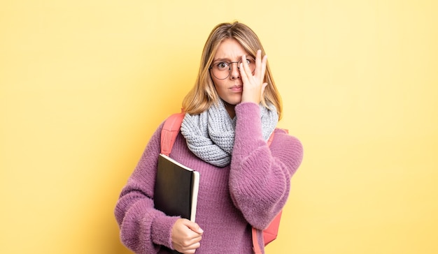 bella ragazza bionda che si sente annoiata, frustrata e assonnata dopo una noiosa. concetto di studente