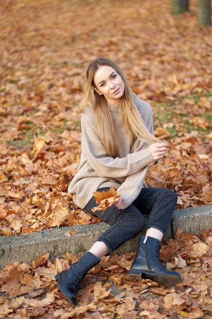 Bella ragazza bionda con bei capelli lunghi che indossa un maglione accogliente