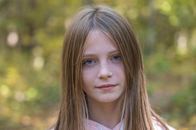 Bella ragazza bionda con le lentiggini all'aperto sullo sfondo della natura in autunno primo piano ritratto