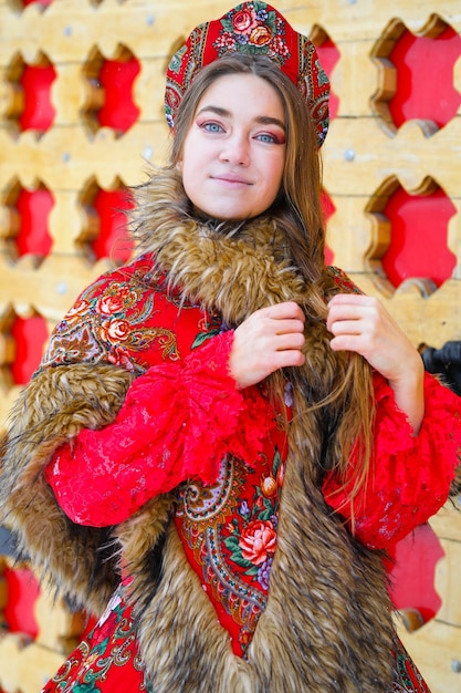 Bella ragazza bionda dai capelli lunghi in abiti nazionali tradizionali russi in inverno