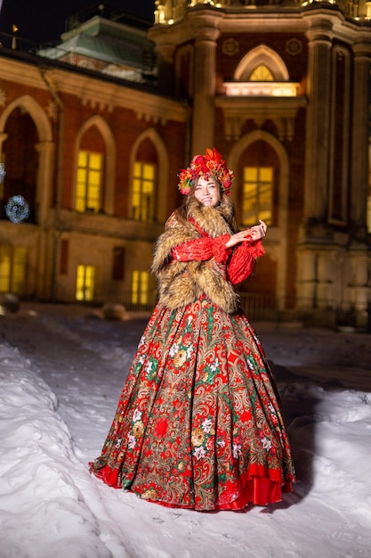 Bella ragazza bionda dai capelli lunghi in abiti nazionali tradizionali russi in inverno