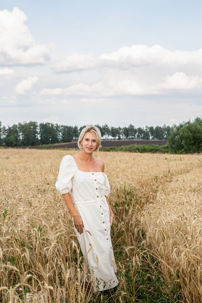 Bella ragazza bionda in un campo di grano