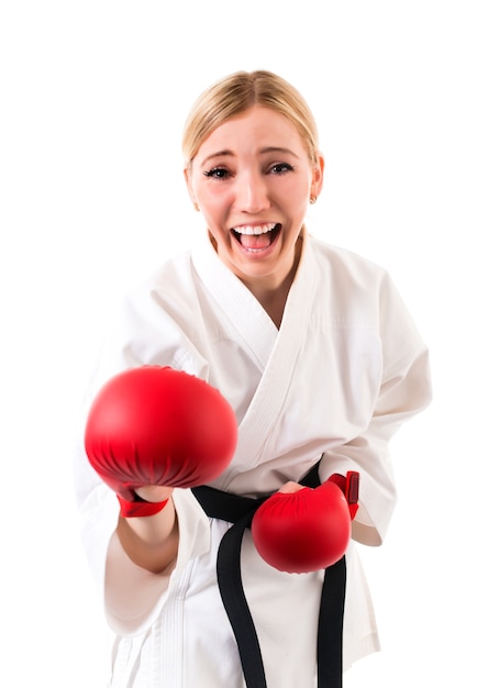 Bella ragazza bionda sportiva di karate in un kimono e guanti rossi