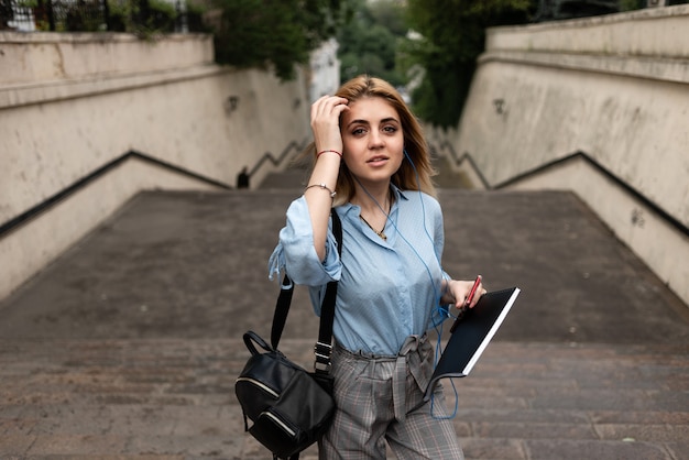 Bella ragazza bionda studentessa sulle scale