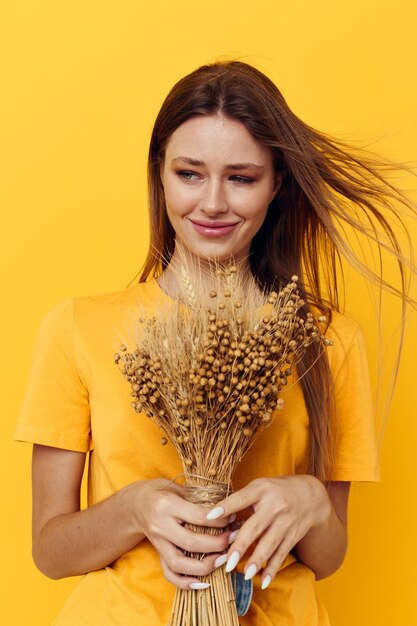 Bella ragazza bouquet di fiori secchi abbigliamento casual sorriso in posa sfondo isolato